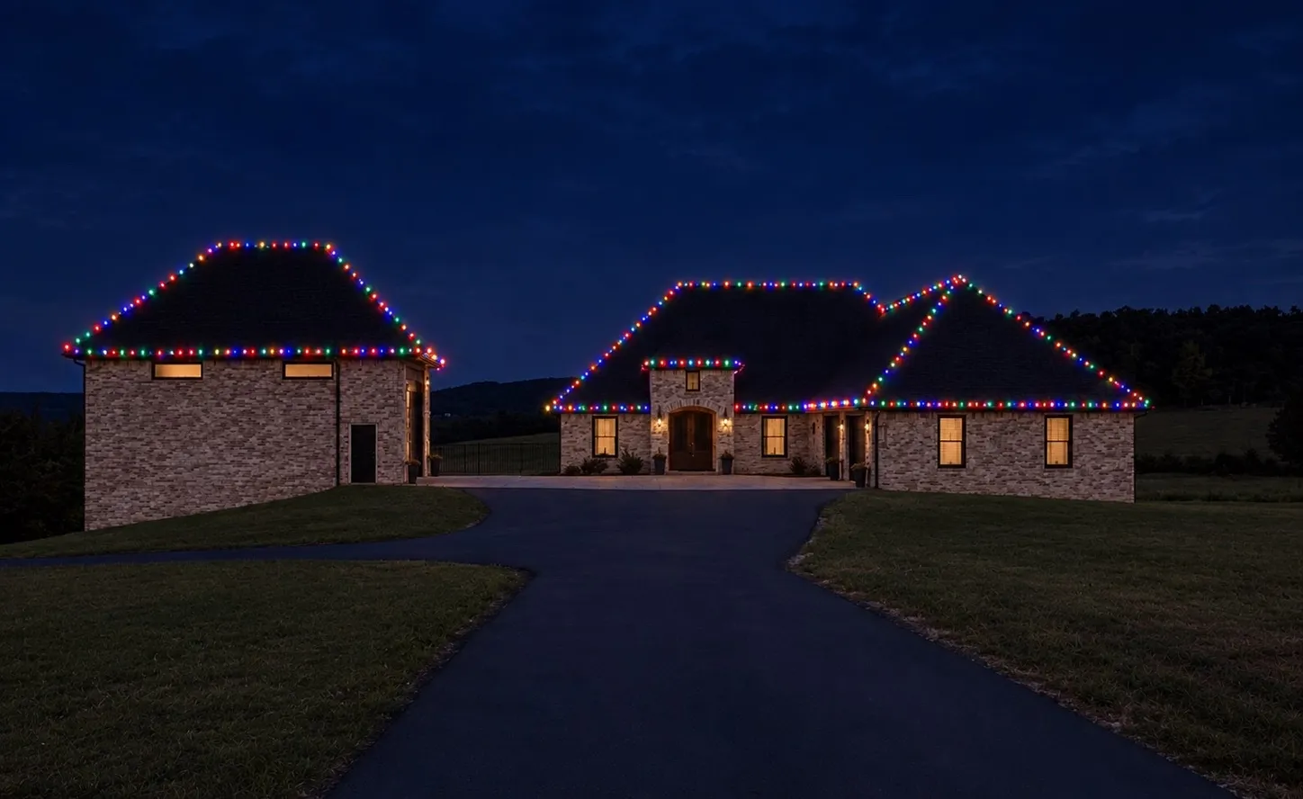 Brick home and detached shop both outlined in multicolor C9 Christmas lights