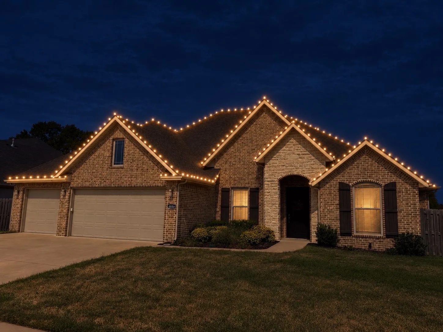 Single-story brick home with warm white C9 lights outlining each gable